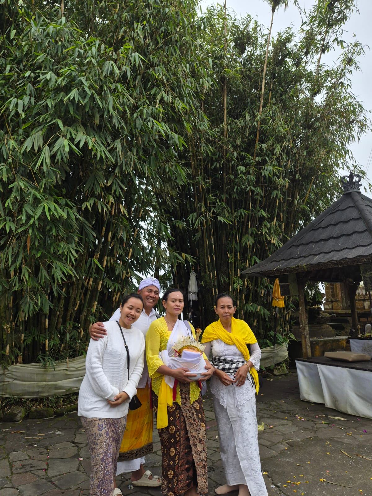 Keluarga berpakaian adat di area pura